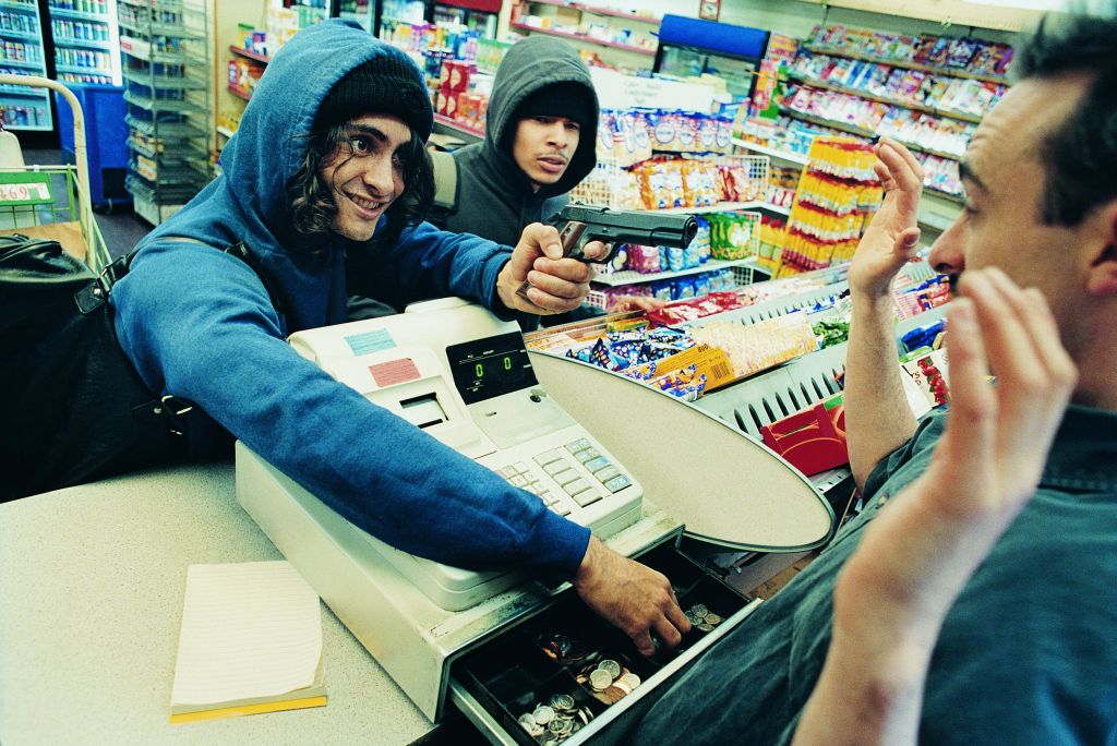 High Angle View of Two Robbers Robbing a Cash Till and Threatening a Shop Assistant with a Gun