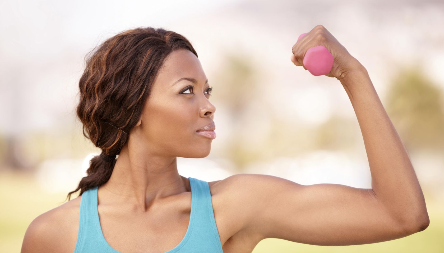 A beautiful african-american woman doing weight training outdoors