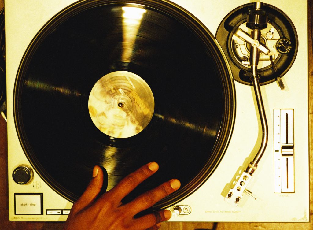 high angle close-up of a hand scratching a vinyl record on a turntable