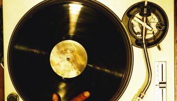 high angle close-up of a hand scratching a vinyl record on a turntable