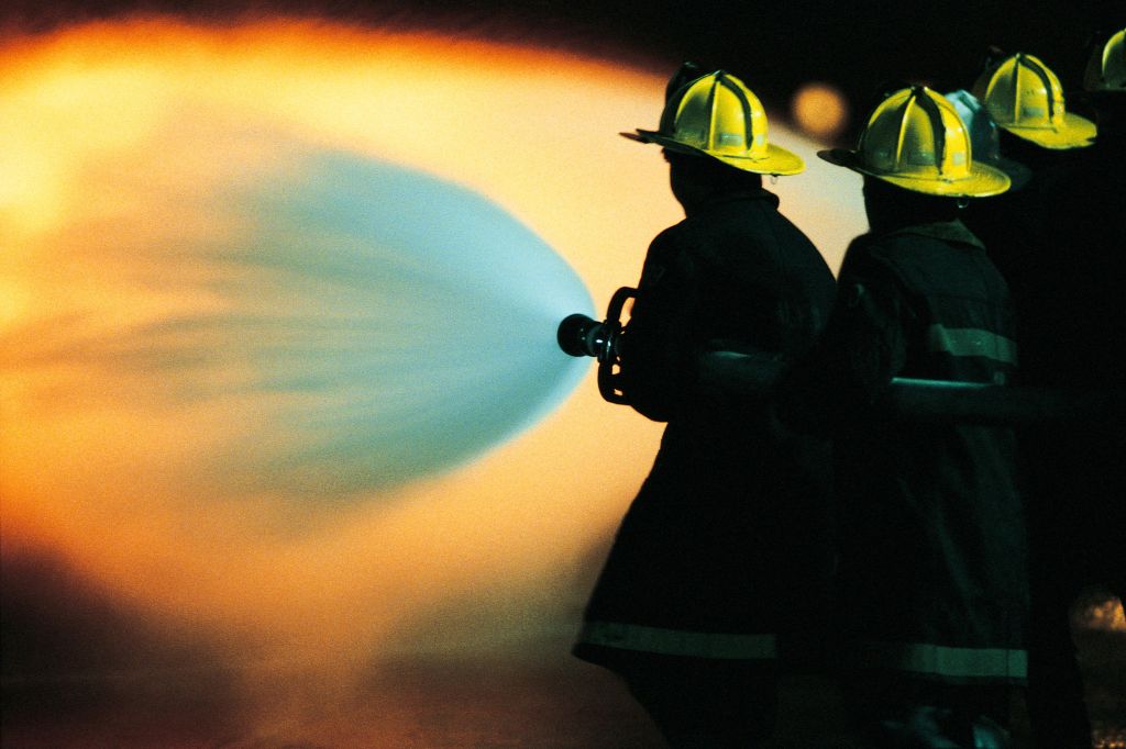Firemen spraying water on fire