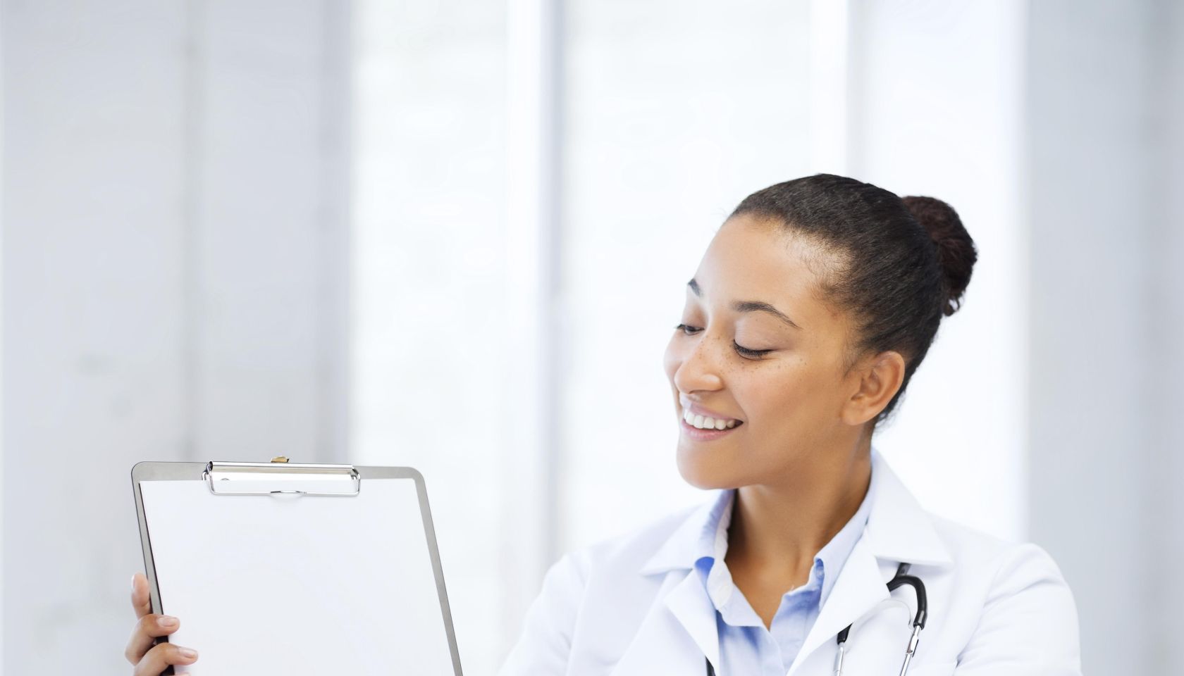 health care and medical concept - female doctor with stethoscope and blank prescription