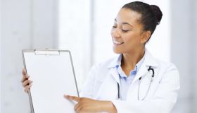 health care and medical concept - female doctor with stethoscope and blank prescription
