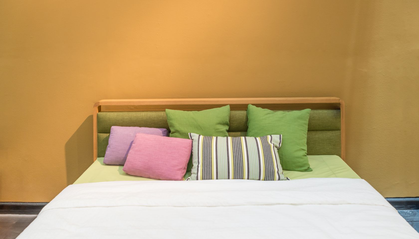 Bedroom interior with bed and colorful pillow of cosy home in modern design. Vintage bedroom.
