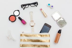 Dressing case with a lot of feminine objects.overhead shot.White background