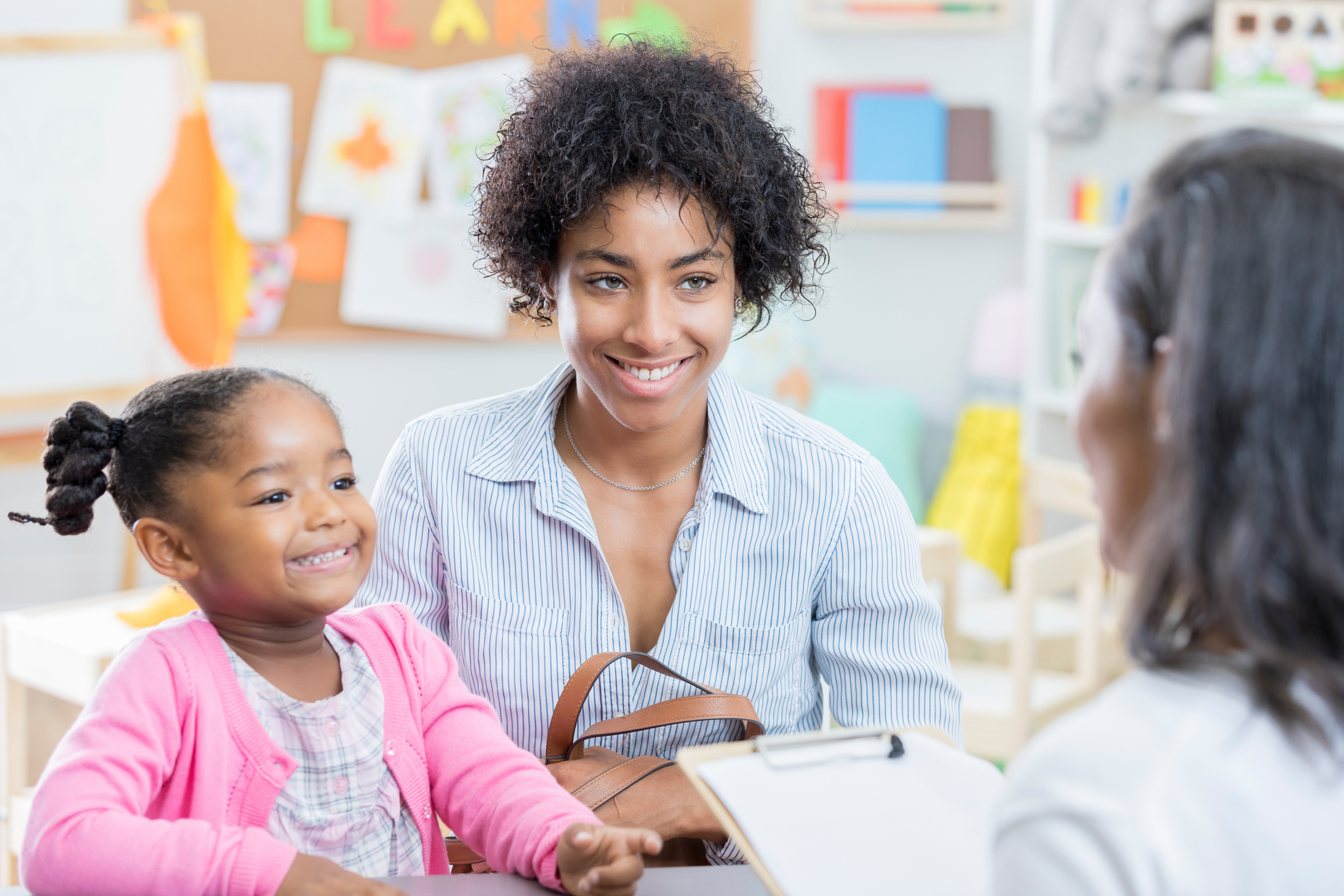 African American mom talks with teacher during conference