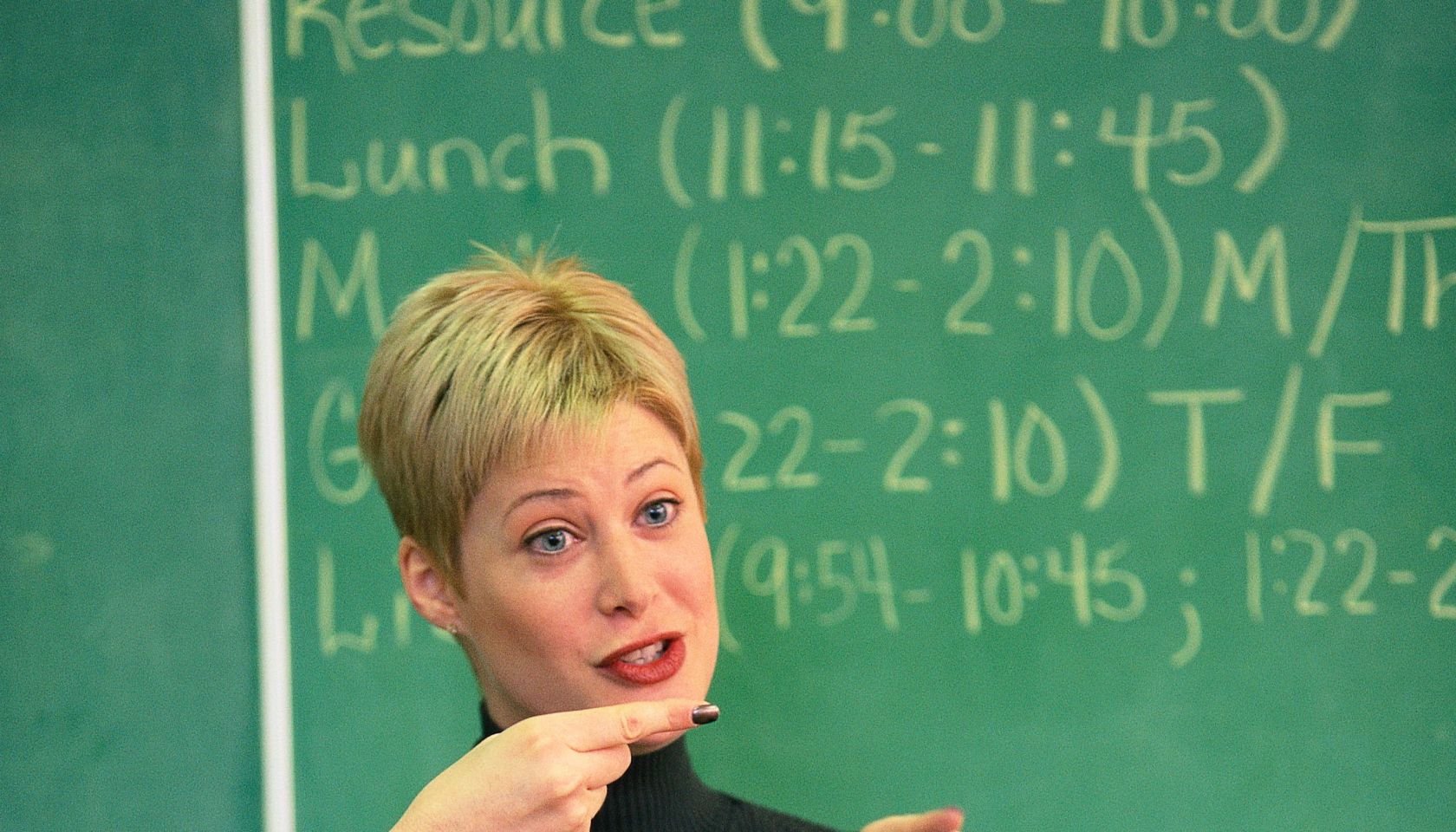 Teacher talking and pointing at front of classroom