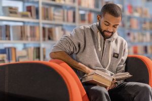 Handsome afro american university student studying alone in a campus library