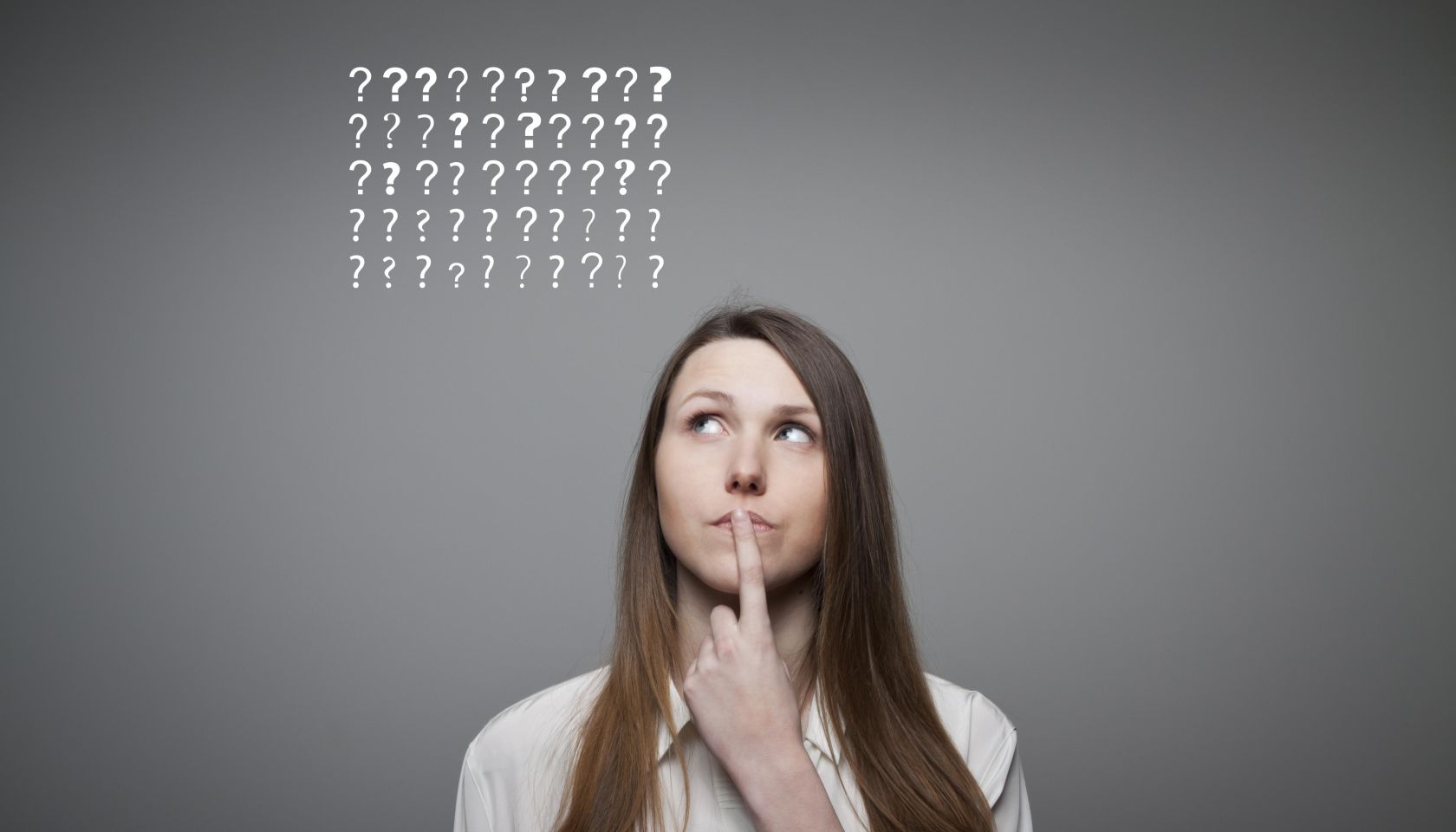 Young woman and many question marks above head