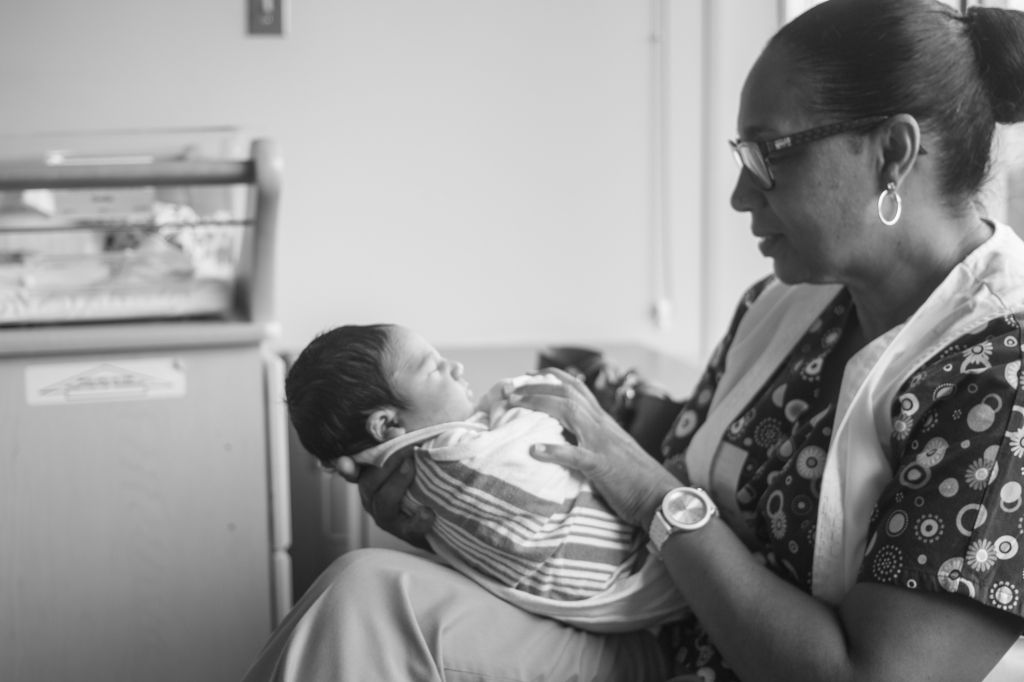 Nurse Holding Newborn Baby At Hospital