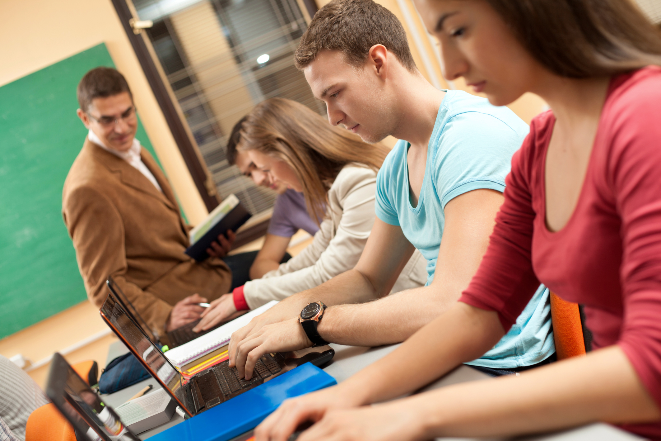 Group of students using computers in classroom.