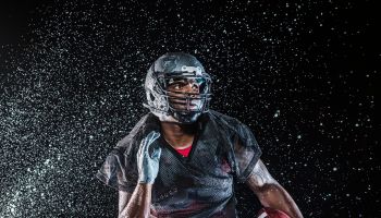 Water splashing on black football player running