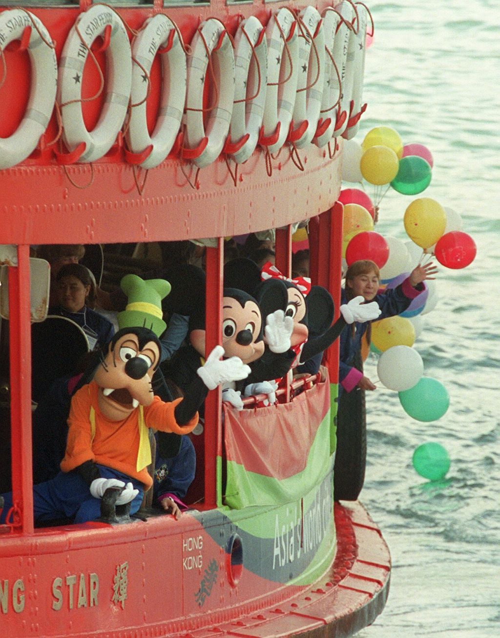 Mickey Mouse , Minnie Mouse and Goofy , Walt Disney cartoon characters , take the Star Ferry to Tsim Sha Tsui.