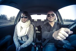 couple with sunglasses driving car merrily