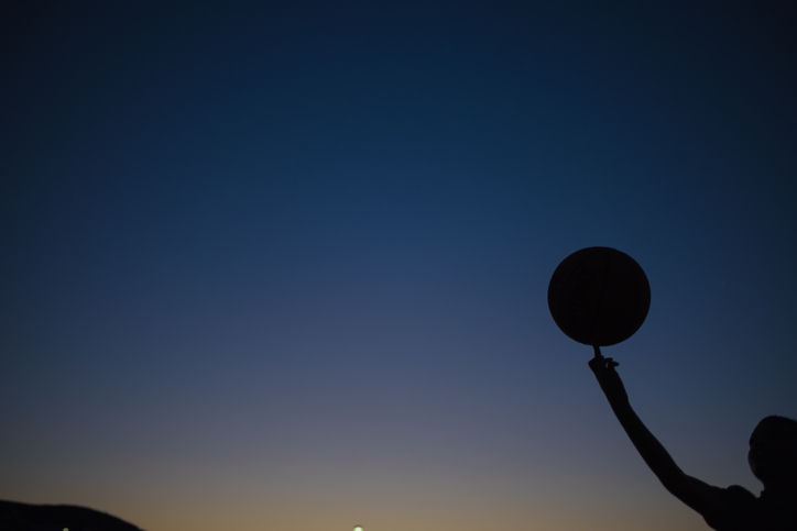 Silhouette Boy Holding Basketball Against Sky During Sunset