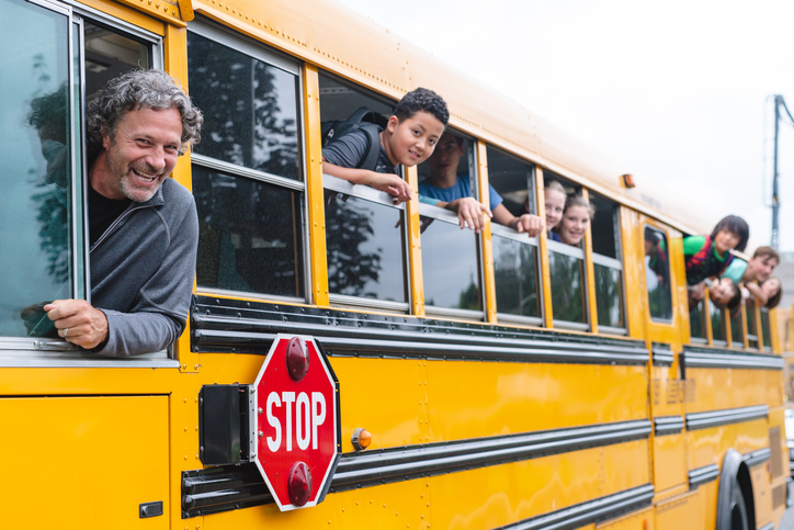 Portrait of bus driver and students on the school bus
