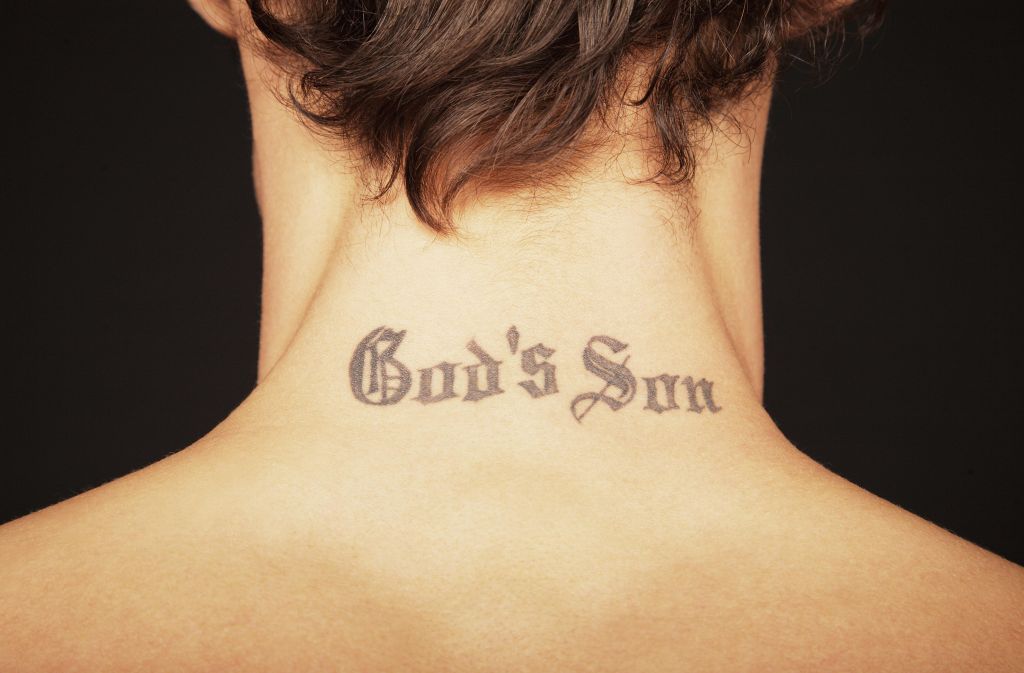 Man with tattoo on neck reading 'God's son', close-up, rear view
