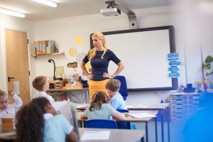 Teacher with hands on hips in front of class at primary school