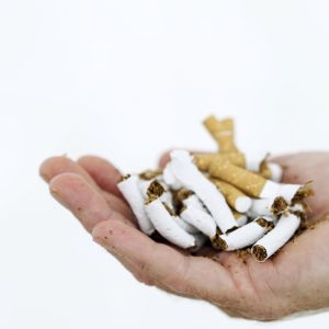 close-up of a man's hand with crushed cigarettes