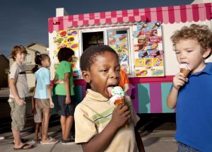 Kids eating ice cream cone by vendor's stall