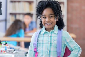 Elementary age little girl smiles for camera at school