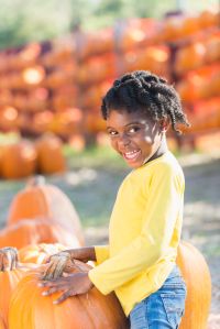 Little African-American girl in a pumpkin patch
