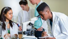 African American high school student record observations in science lab