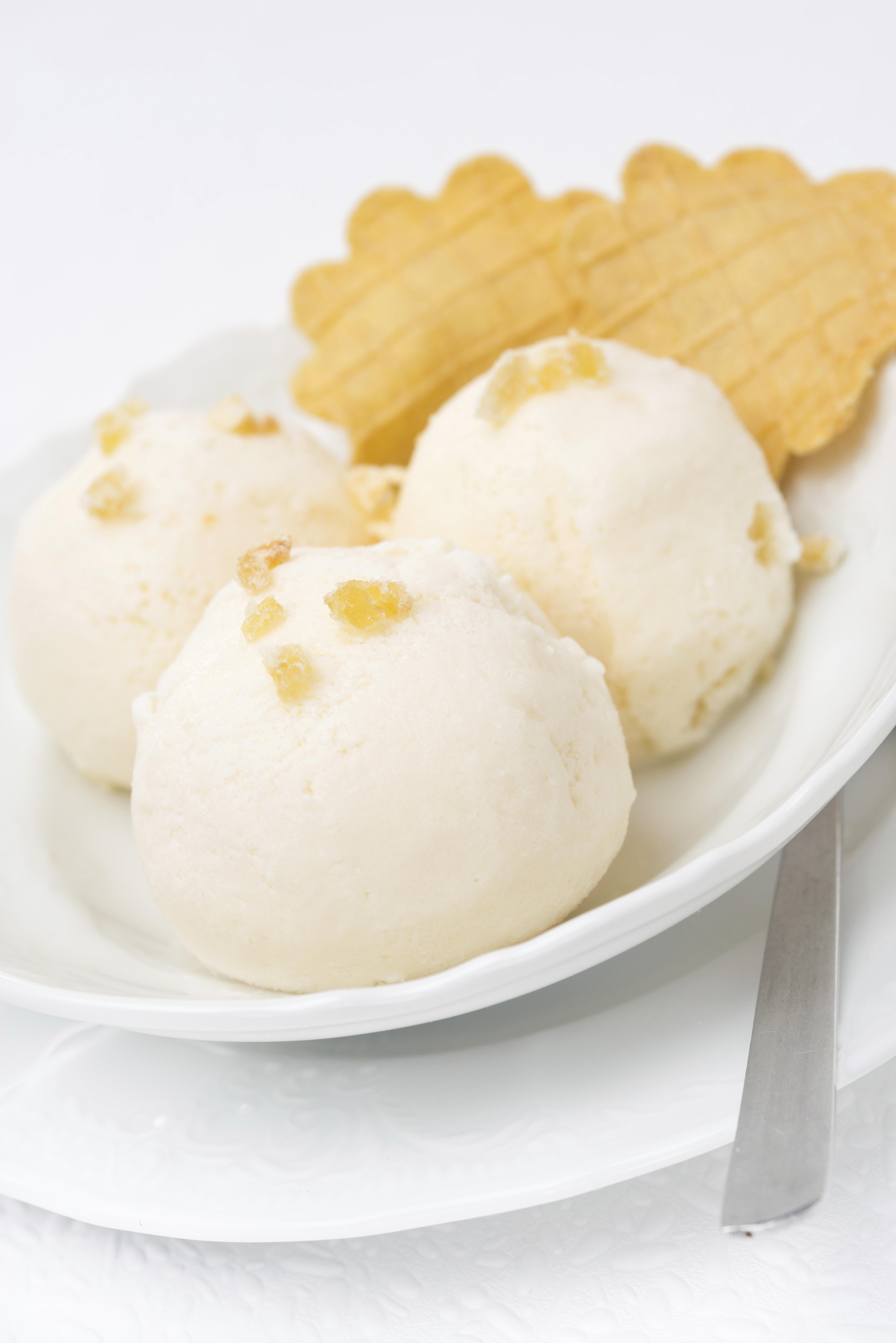 Ginger ice cream with melted milk, thin waffles close-up vertical