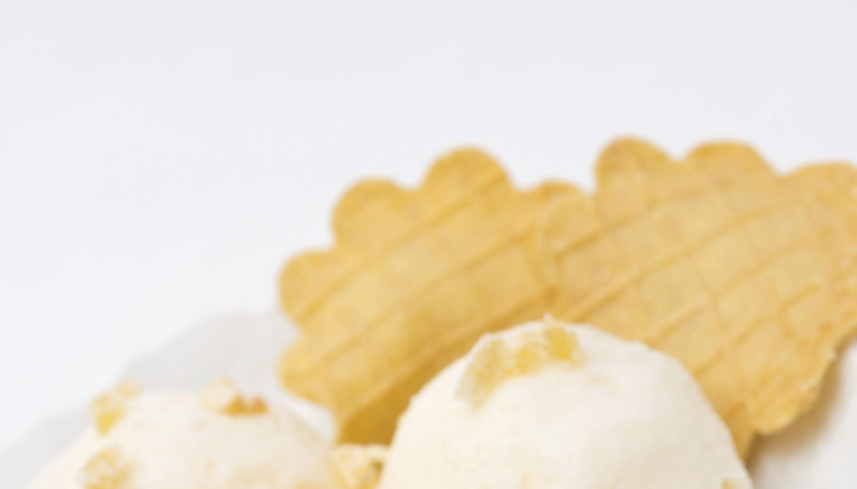 Ginger ice cream with melted milk, thin waffles close-up vertical