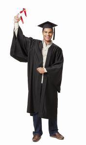 Male graduate holds up a diploma while wearing a graduation gown. Vertical shot. Isolated on white.