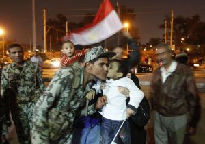 An Egyptian boy kisses a soldier as anti