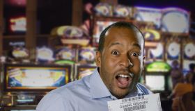 Excited African American man holding gaming voucher in casino