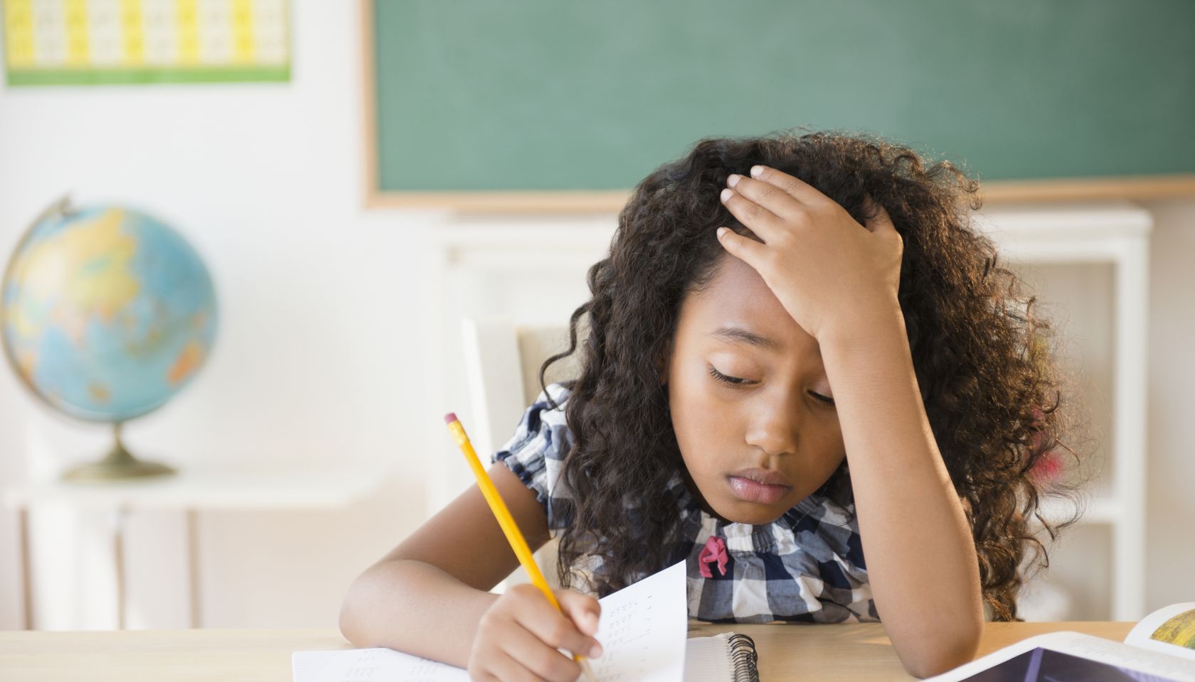 Frustrated mixed race student working in classroom