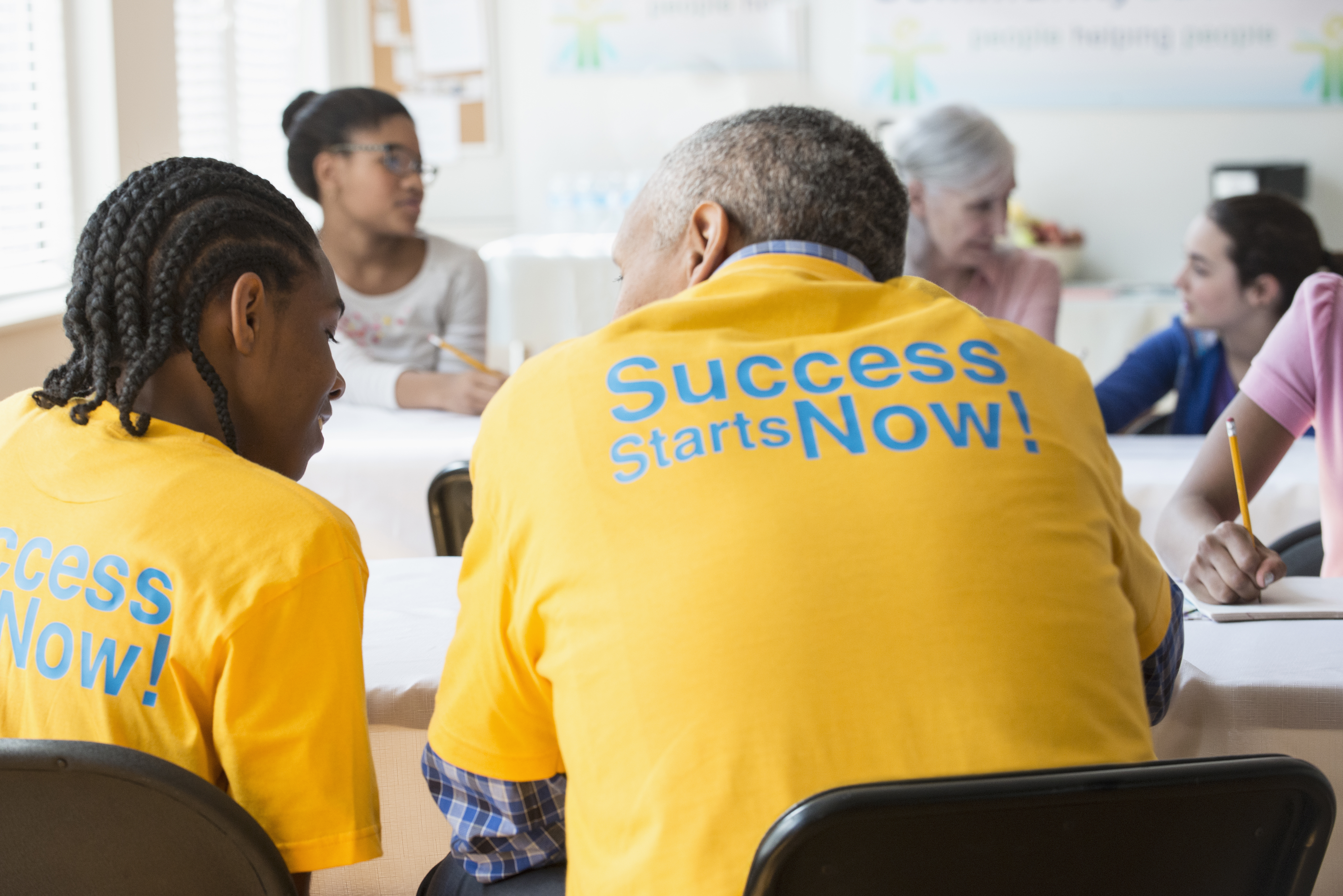Volunteers tutoring students in classroom