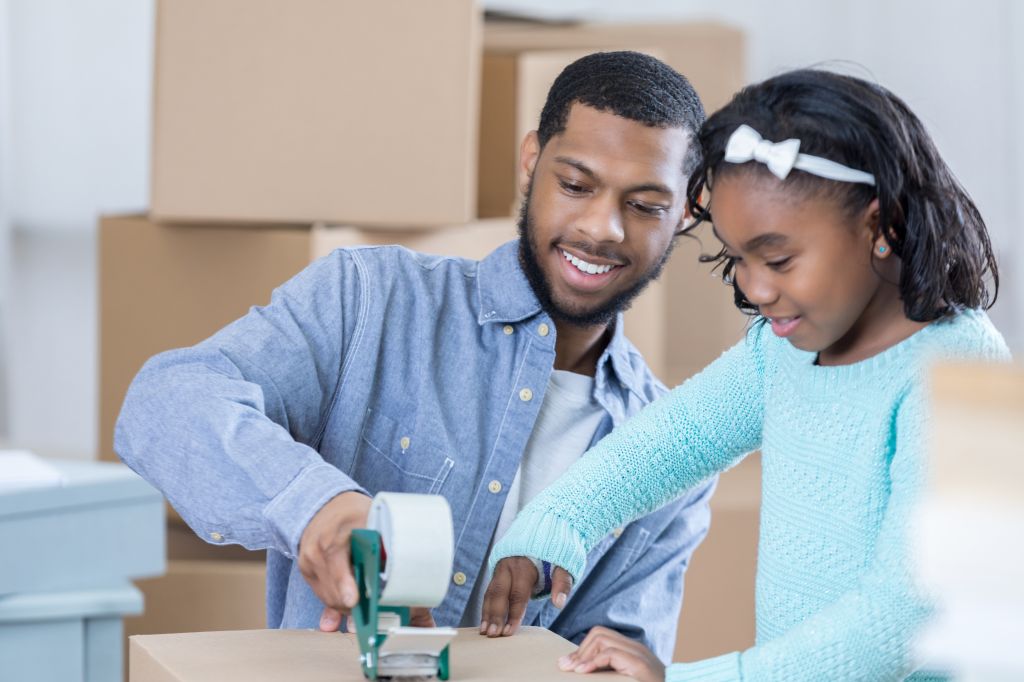 African American father and daughter prepare to move