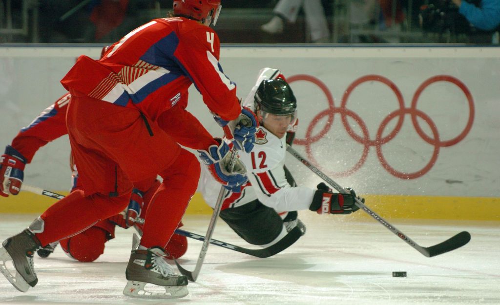 TURIN, ITALY. WEDNESDAY, FEBUARY 22, 2006. The Winter Olympics mens hockey quarterfinals are going on.Russia faced Canada at the Torino Esposizioni. In the first period Russian player #61 Maxim Afinogenov (hidden) takes down Canadian player #12 Jarome Igi