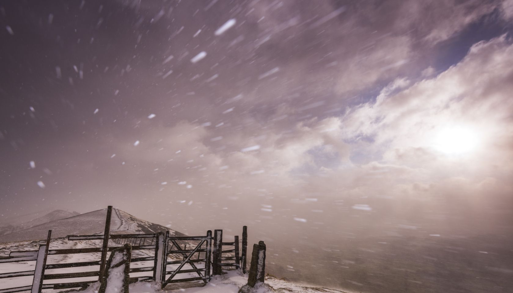 Severe blizzard conditions over Mam Tor at sunrise in the Peak District National Park, Derbyshire