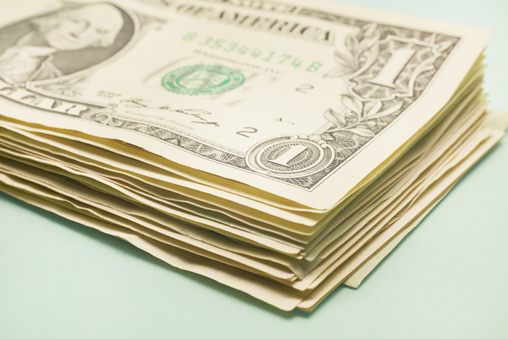Stack of American Dollar banknotes on turquoise background