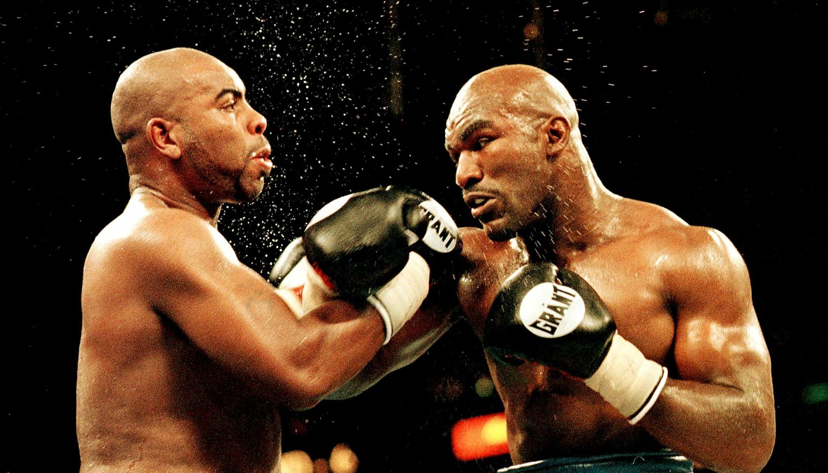 Heavyweight champion Evander Holyfield (R) follows