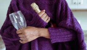Woman Holds Bottle of Wine and Glass