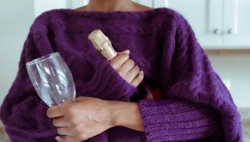 Woman Holds Bottle of Wine and Glass