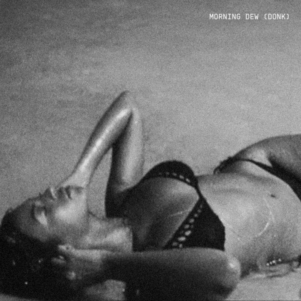 Black and white image of a person lying on their back, with their legs raised and visible.